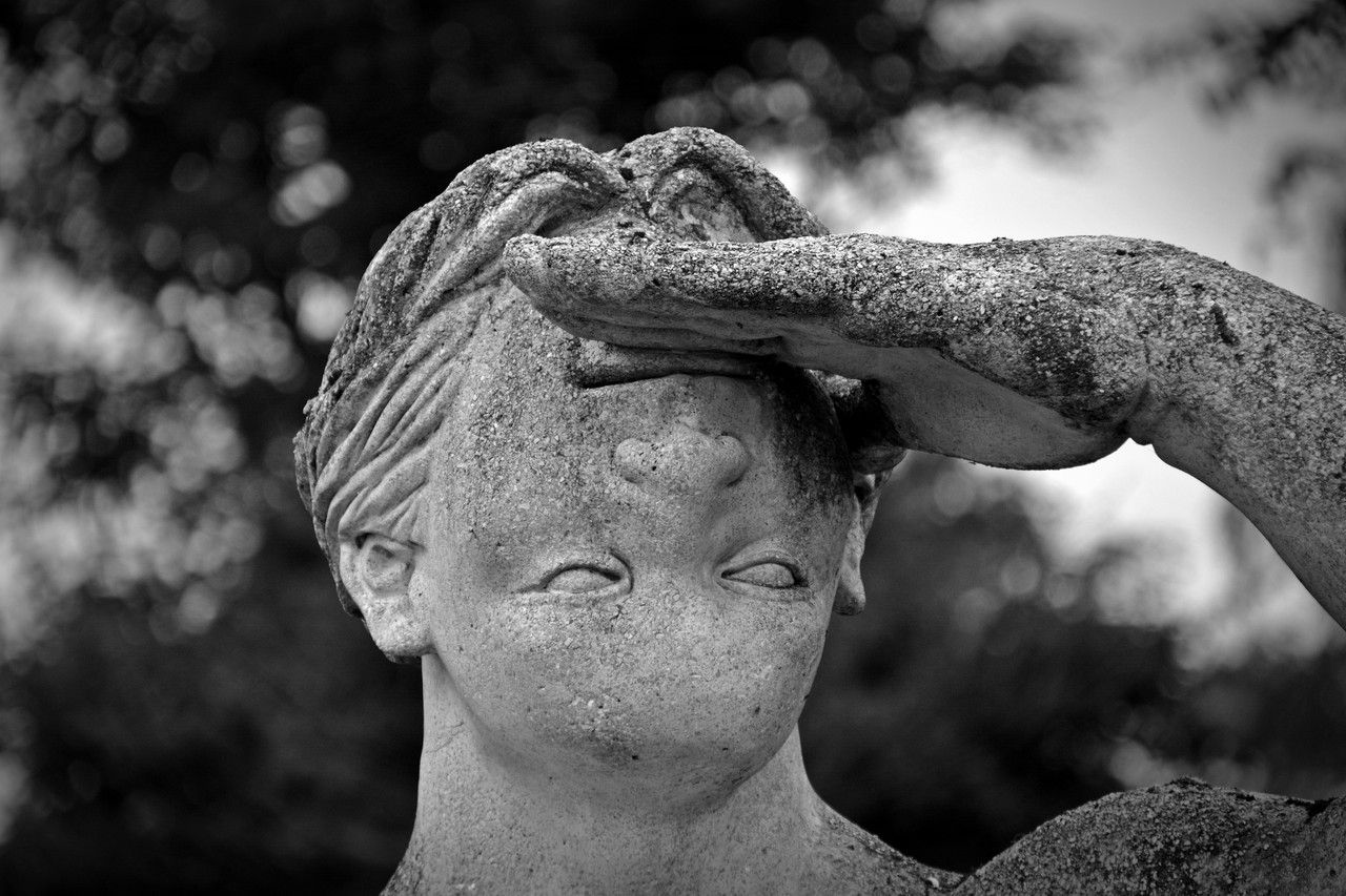 estátua de homem com feições de cabeça para baixo preto e branco